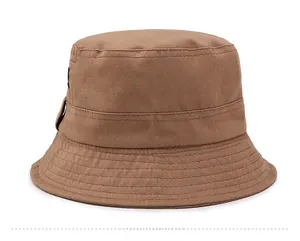 Detail view of brown cotton sun hat side profile with multi-row stitched brim and woven label