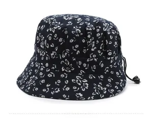 Detail view of navy blue floral sun hat with white flower pattern and side drawstrings