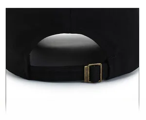 Dettaglio macro della fibbia regolabile in metallo bronzo sul cappello in cotone nero