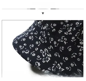 Detail of navy blue sun hat with white floral print and precise brim stitching