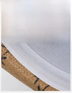 Gros plan du bandeau intérieur et de l'imprimé palmier sur un chapeau de paille