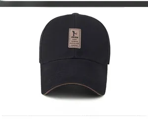 Detail of black cotton baseball cap with brown leather label and stitched brim edge