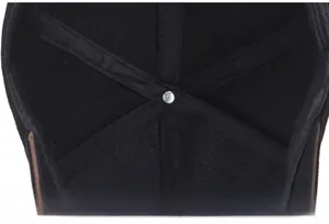 Detail view of the six-panel interior construction and metal center button on a black cap