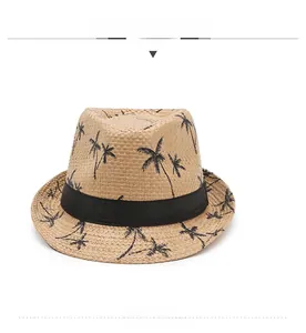 Vue de face d'un chapeau de paille fedora avec motifs de palmiers noirs et ruban