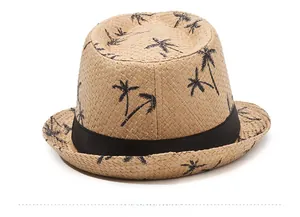 Détail de la texture tressée et des motifs palmiers noirs sur un chapeau de paille d'été
