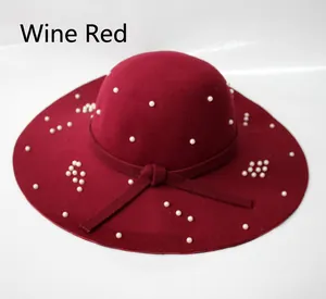 Détail d'un chapeau en laine bordeaux avec perles blanches et nœud en feutre assorti