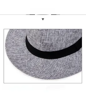 Detail view of the wide brim grey woven sun hat with a decorative black ribbon band