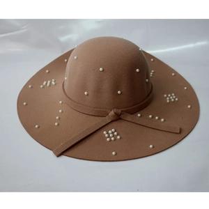 Vue détaillée d'un chapeau en laine marron orné de perles blanches et d'un ruban décoratif