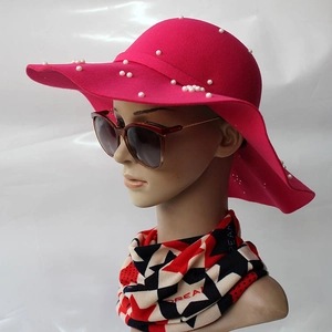 Détail d'un chapeau en laine rose à large bord avec perles artificielles élégantes