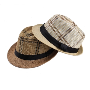 Detailed view of woven straw hats featuring classic plaid patterns and black satin ribbons