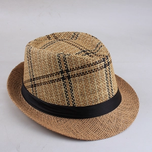 Macro detail of natural straw weave texture and black plaid pattern on a fedora hat
