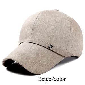 Detail of beige summer baseball cap featuring fine textured fabric and metal shield logo