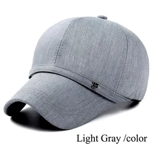 Close-up of light gray baseball cap featuring fine twill texture and shield metal logo