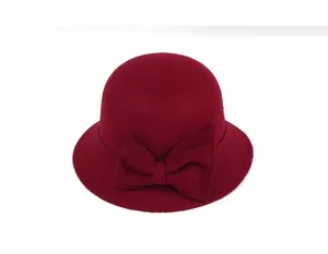 Detail view of burgundy wool felt cloche hat featuring a large side bow decoration