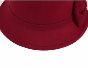 Detailed close-up of wine red wool cloche hat showing decorative band and fine stitching