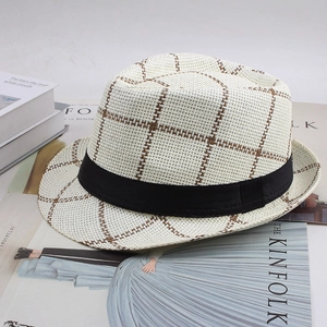 Détail d'un chapeau de paille d'été avec motif à carreaux sur un magazine chic