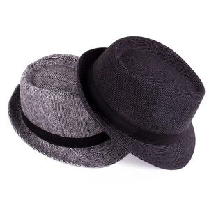 Macro view of grey and black herringbone fedora hats with textured wool fabric