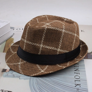 Vue de dessus d'un chapeau de paille marron à carreaux avec ruban en tissu noir élégant