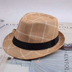 Détail de la texture tissée à carreaux et du ruban noir sur ce chapeau de paille d'été