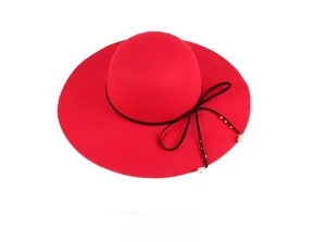 Detail of red wool fedora hat featuring black ribbon bow with elegant pearl accents