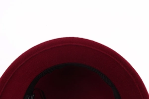 Close-up of inner stitching and polyester material label on a red wool felt cloche hat