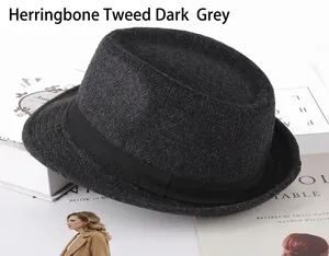 Detailed view of dark grey herringbone wool fedora with black ribbon on books