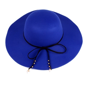 Close-up of royal blue wool fedora hat featuring black bow and pearl charm pendant