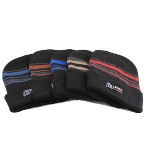 Detail of five winter beanies with colored stripes and sport labels on a white backdrop
