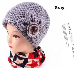 Detail of grey knitted hat featuring handmade jacquard floral accent and thick yarn texture