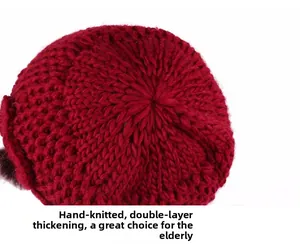 Close-up of red hand-knitted winter hat with double-layered thickness and top pompom