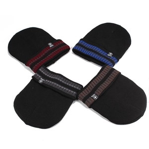 Détails de quatre bonnets d'hiver avec revers rayés colorés et emblèmes de sport