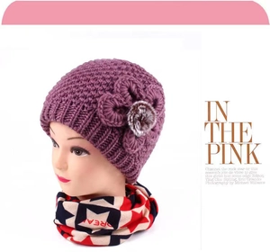 Detail of purple knitted hat with floral fur pom-pom and star pattern scarf set