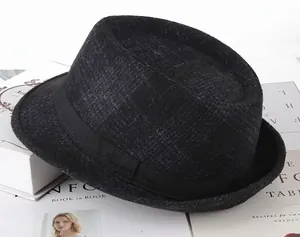 Detail of herringbone wool fedora hat with a black ribbon band on vintage books