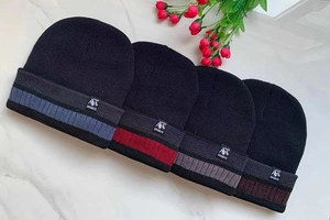 Detail of four knit beanies in navy, black, and brown with woven SPORTS logo patch