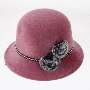 Détail d'un chapeau d'hiver en peluche rose avec fausse fourrure et pompons décoratifs