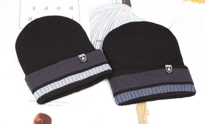 Close-up of black knitted beanies with striped cuffs and star logo on magazine background