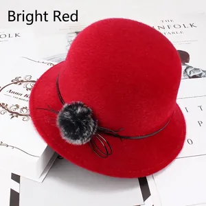 Détail d'un chapeau cloche d'hiver rouge en imitation vison avec pompon et ruban décoratif