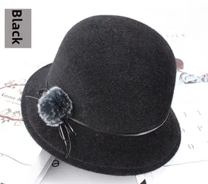 Détail chapeau cloche d'hiver noir avec pompon gris et petit nœud en cuir élégant