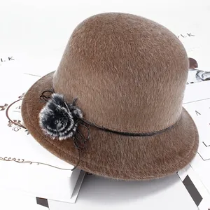 Détail d'un chapeau cloche camel en fausse fourrure avec pompon texturé et petit nœud