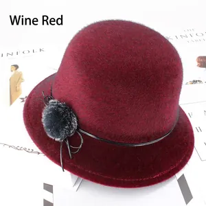Détail du chapeau cloche bordeaux en fausse fourrure avec nœud noir et pompon élégant