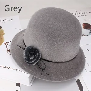 Détail du chapeau cloche d'hiver gris avec pompon en fourrure et ruban cuir