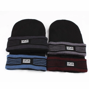 Detail of four knit beanies with striped brims and sports fashion fabric patches