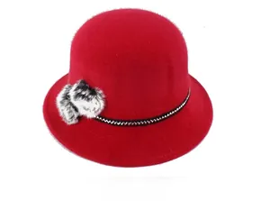 Détail du chapeau cloche rouge en fausse fourrure avec pompons et ruban tissé décoratif