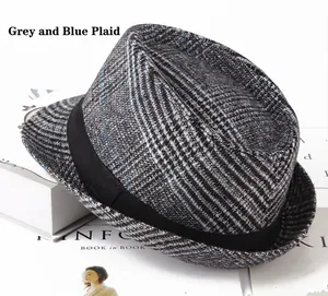 Macro detail of grey blue plaid fedora hat with elegant black ribbon on a magazine