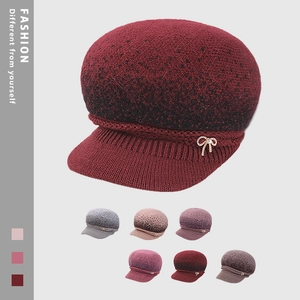 Detailed knit texture of burgundy winter hat with sparkling rhinestone butterfly brooch
