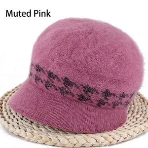 Close-up of dusty pink knit winter hat featuring a fuzzy texture and dark pattern band