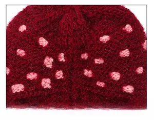 Detail shot of the reinforced top stitching on the thick dark red knitted winter beanie