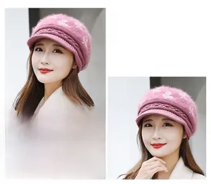 Close-up of pink knit visor beanie with plush rabbit fur texture and white diamond pattern