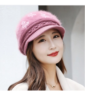 Close-up of pink knit rabbit fur hat with white floral jacquard and a sturdy visor