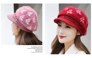 Detail of pink and red knit hats featuring textured leaf patterns and cozy brim design